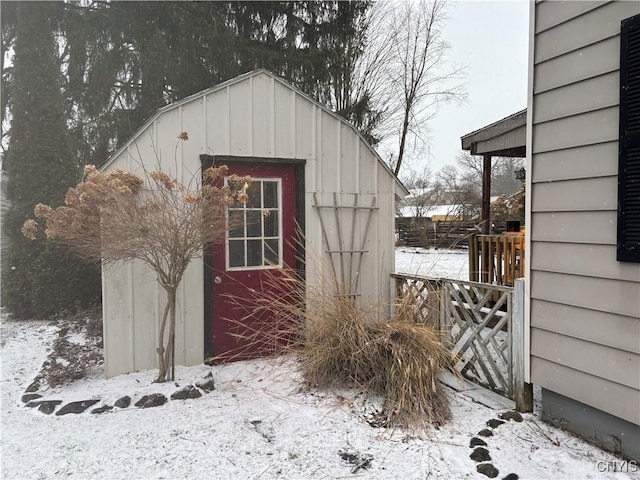 snow covered structure featuring an outbuilding