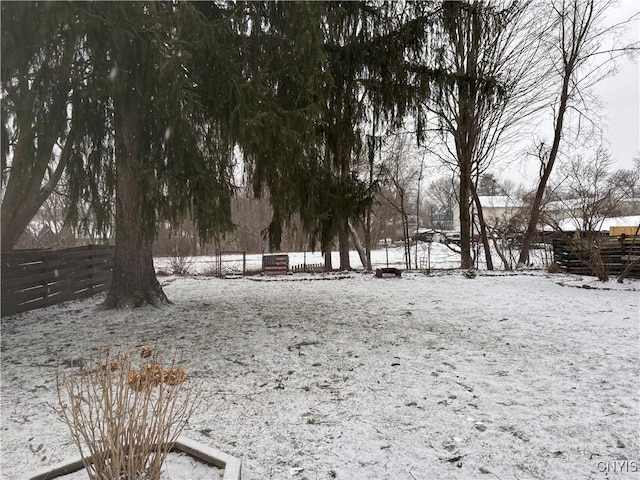 yard covered in snow featuring fence