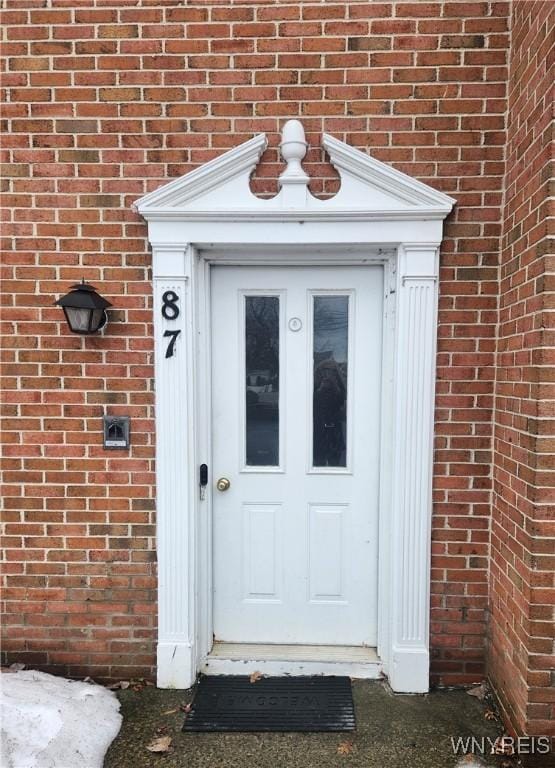 entrance to property featuring brick siding