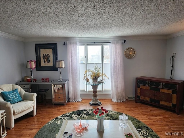 sitting room with crown molding, a textured ceiling, and wood finished floors