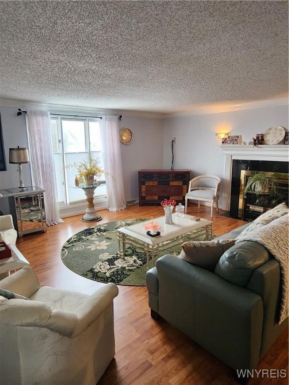 living area featuring a textured ceiling, a fireplace, and wood finished floors