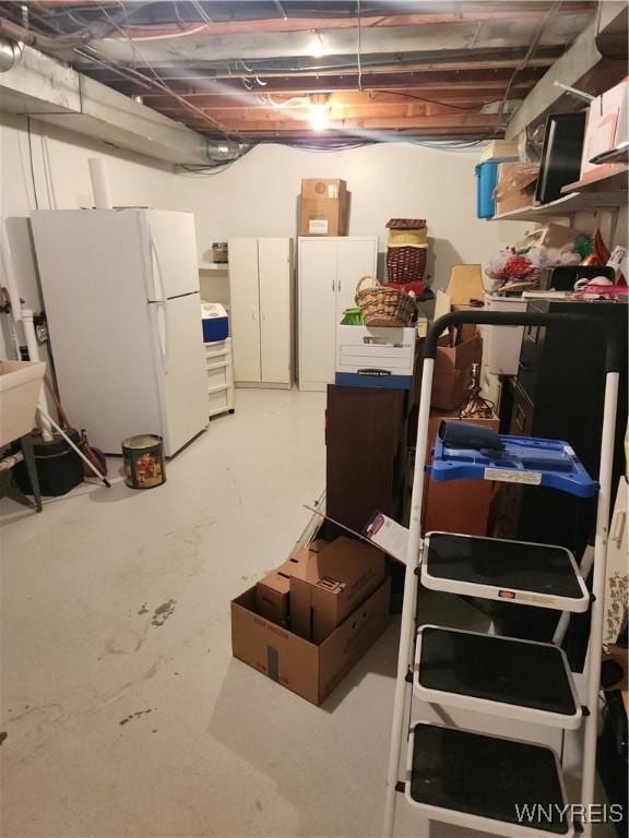 unfinished basement featuring freestanding refrigerator