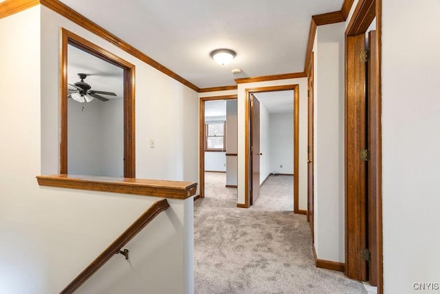 hall with light carpet, baseboards, an upstairs landing, and crown molding