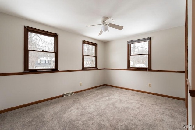 empty room with a ceiling fan, baseboards, visible vents, and carpet flooring