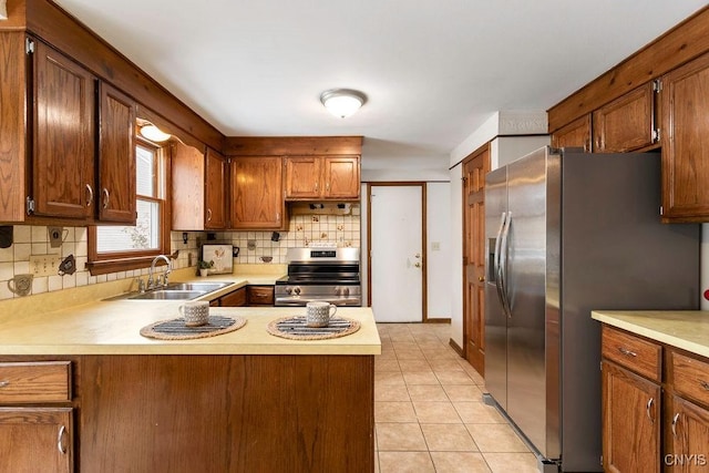 kitchen with light tile patterned floors, light countertops, appliances with stainless steel finishes, and a sink