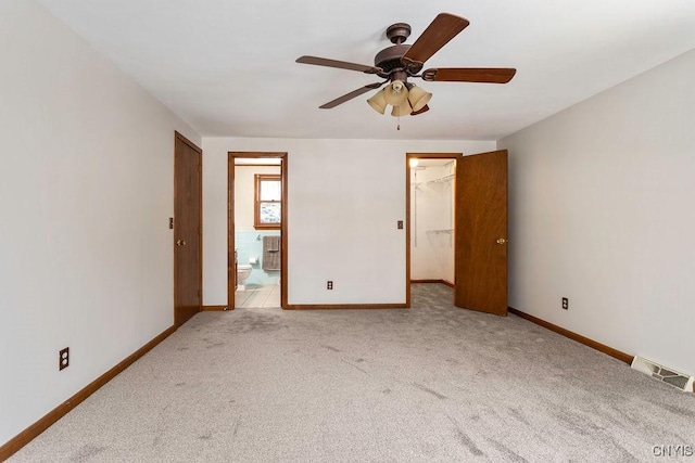 unfurnished bedroom featuring a closet, light carpet, visible vents, and baseboards