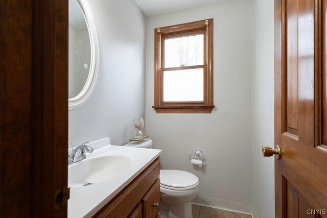 bathroom featuring toilet, baseboards, vanity, and tile patterned floors