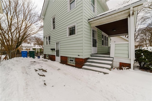 view of snow covered exterior with fence