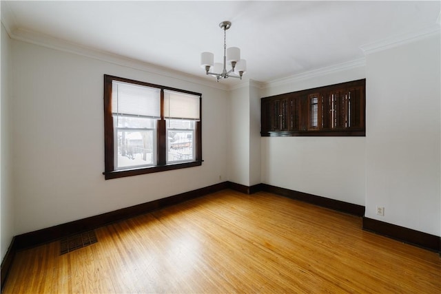 spare room with crown molding, visible vents, and light wood-style floors