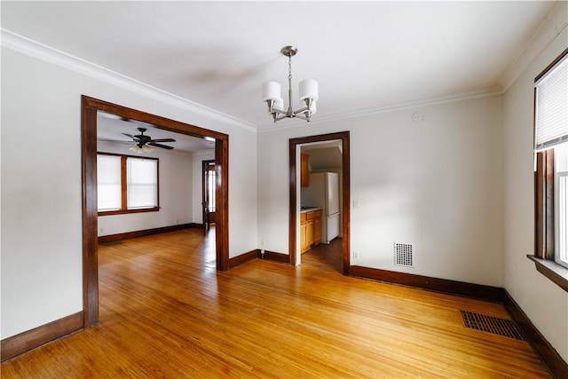 empty room featuring light wood-type flooring, visible vents, a notable chandelier, and ornamental molding