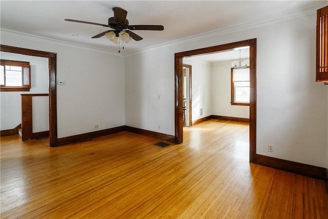 unfurnished room featuring light wood-type flooring, baseboards, visible vents, and ornamental molding