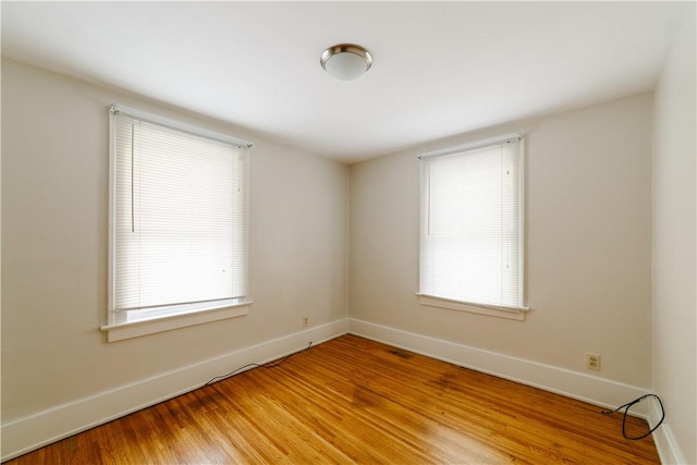 empty room featuring light wood-style flooring and baseboards