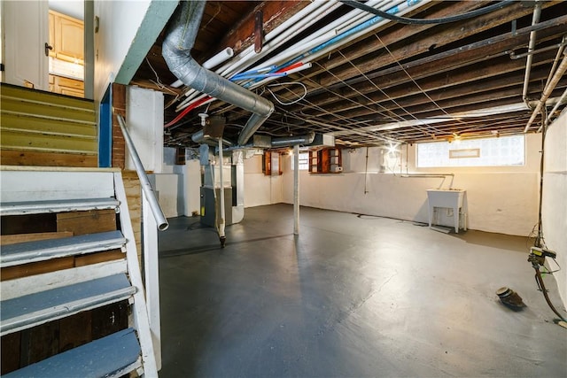 basement with heating unit and stairway