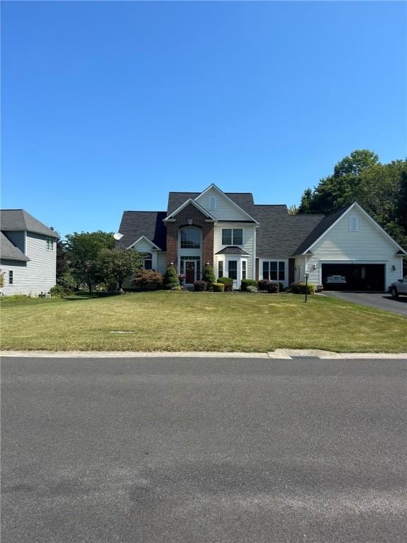 view of front of home featuring a garage, a front lawn, and aphalt driveway