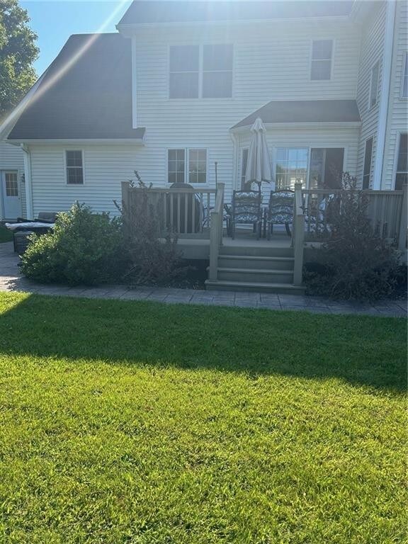 rear view of house featuring a lawn and a wooden deck