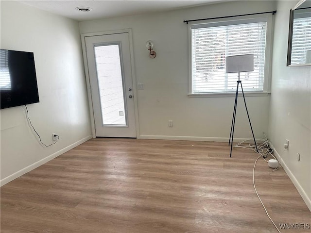 interior space with light wood finished floors, visible vents, plenty of natural light, and baseboards