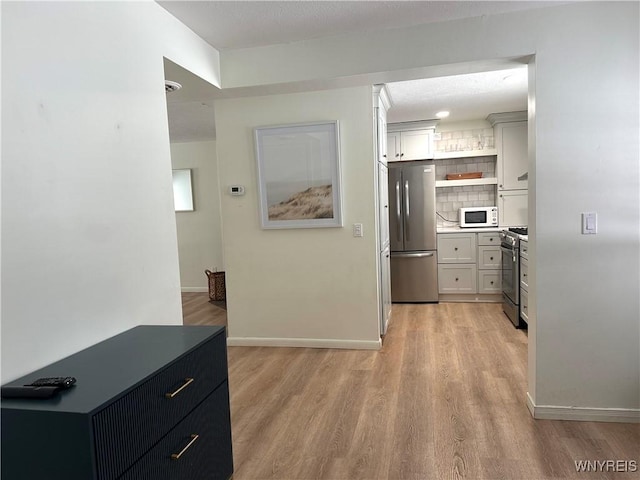 hallway with light wood-style flooring and baseboards