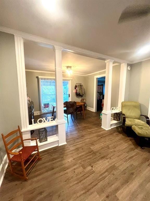 sitting room with crown molding and ornate columns