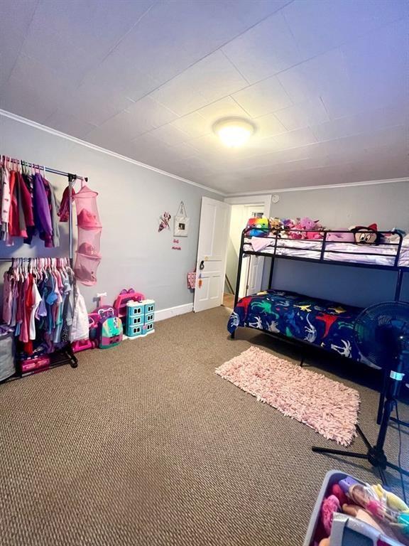 carpeted bedroom with baseboards and ornamental molding