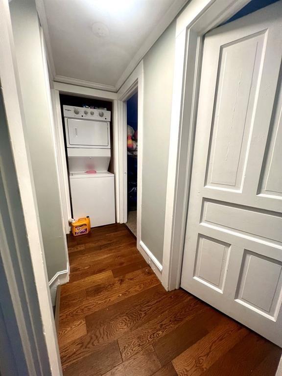 hall featuring dark wood-type flooring and stacked washer and clothes dryer