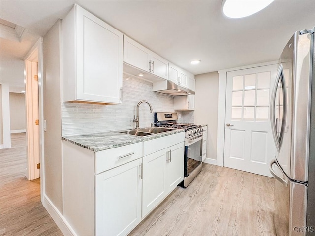 kitchen with light wood-type flooring, white cabinetry, appliances with stainless steel finishes, and a sink