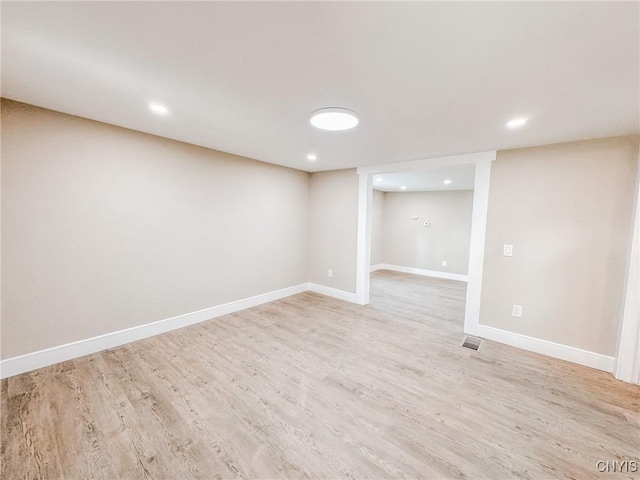 finished basement featuring light wood-type flooring, baseboards, and recessed lighting