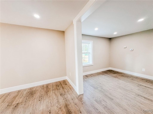 below grade area with recessed lighting, light wood-style flooring, and baseboards