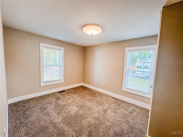 carpeted spare room with baseboards and visible vents