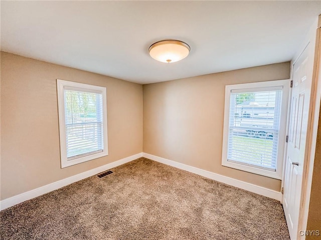 spare room with baseboards, visible vents, and a wealth of natural light