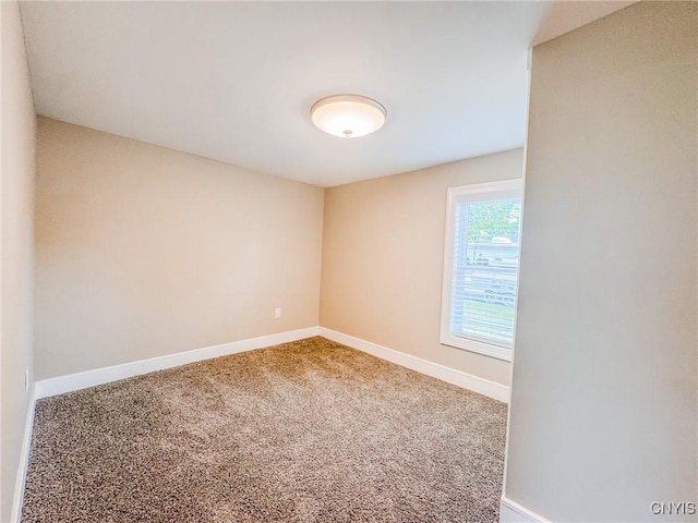 carpeted spare room featuring baseboards