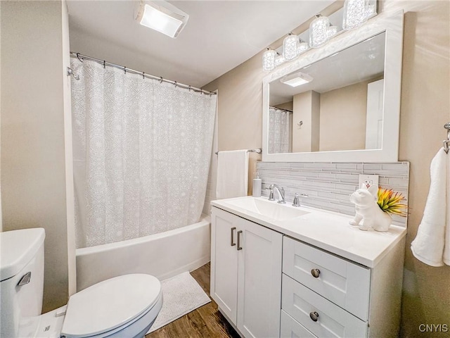 bathroom with toilet, wood finished floors, vanity, decorative backsplash, and shower / bathtub combination with curtain