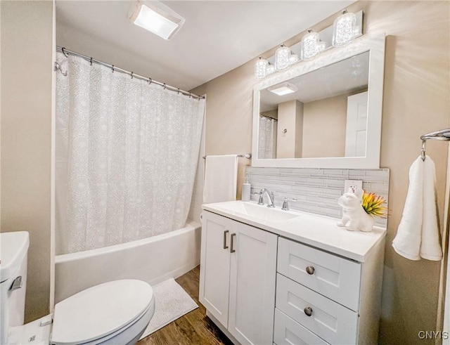 bathroom featuring vanity, wood finished floors, backsplash, and toilet