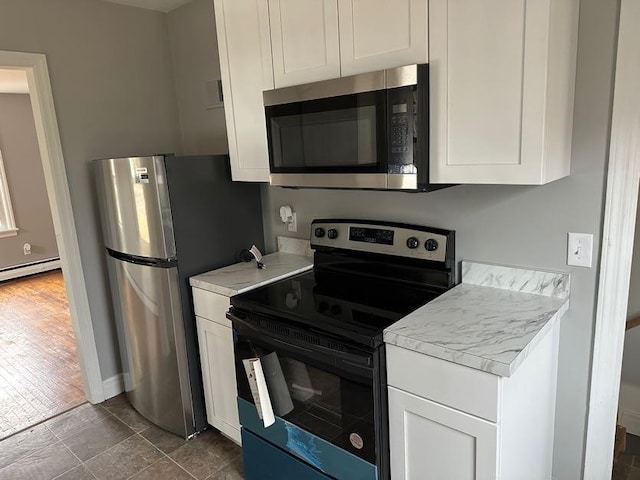 kitchen featuring stainless steel appliances, light countertops, white cabinetry, and a baseboard radiator