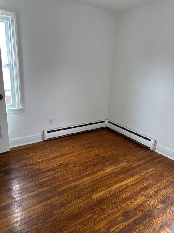 empty room featuring wood finished floors and baseboards