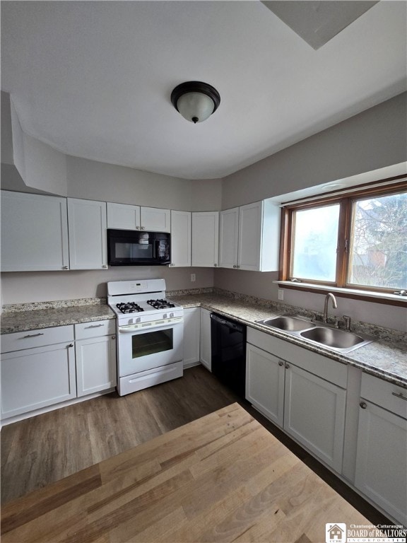 kitchen with dark wood-style flooring, white cabinets, a sink, and black appliances