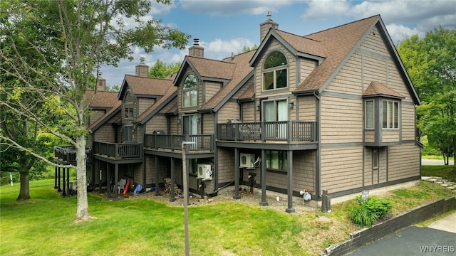 back of property with a shingled roof and a yard