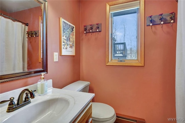 bathroom with baseboard heating, vanity, and toilet