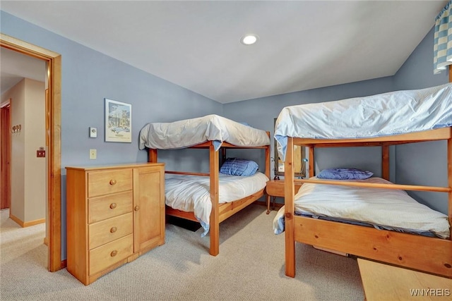 carpeted bedroom featuring vaulted ceiling and baseboards