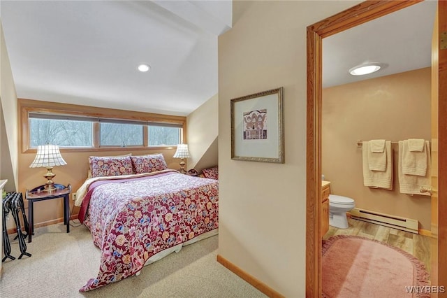 bedroom featuring carpet, baseboards, baseboard heating, and ensuite bathroom