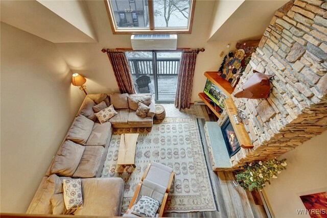 living area with a towering ceiling and an AC wall unit