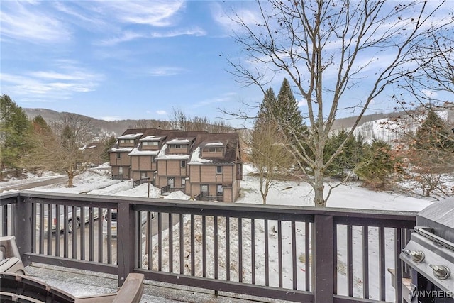 snow covered deck with a residential view and a mountain view