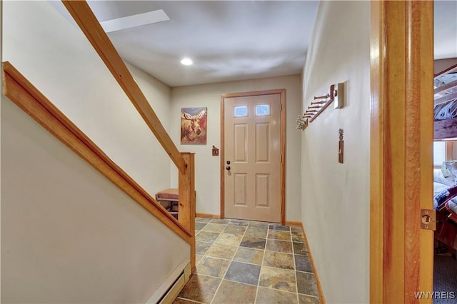 entryway with stone finish floor, baseboards, and stairs