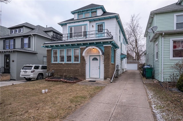 american foursquare style home featuring a garage, brick siding, an outdoor structure, and a balcony