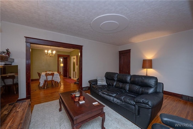 living area featuring an inviting chandelier, wood finished floors, and baseboards