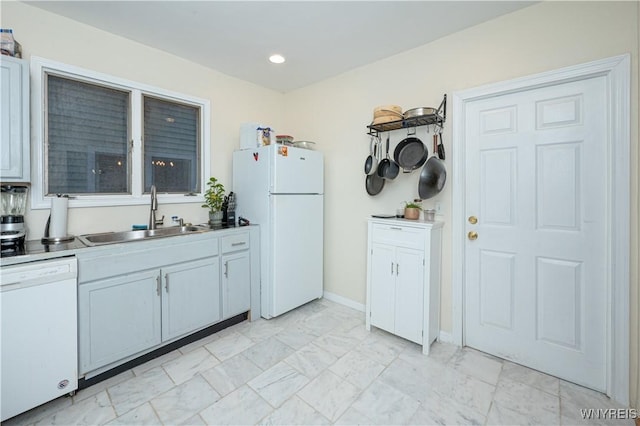 kitchen with marble finish floor, recessed lighting, a sink, white appliances, and baseboards