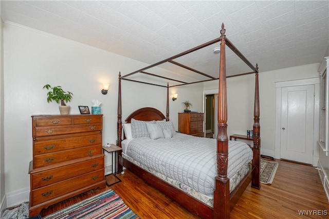 bedroom with wood finished floors and baseboards