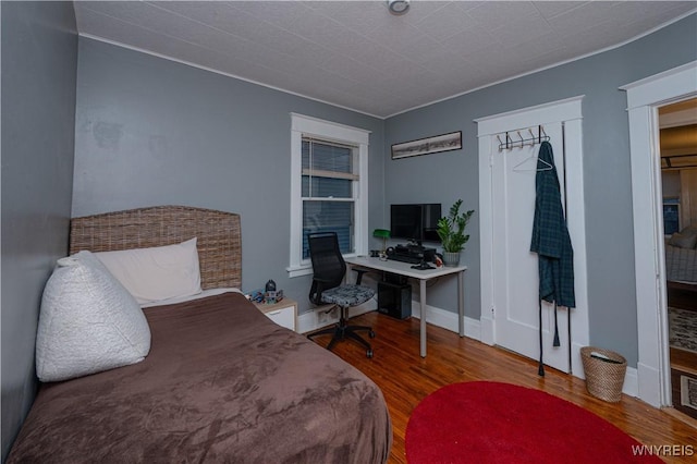 bedroom featuring baseboards and wood finished floors