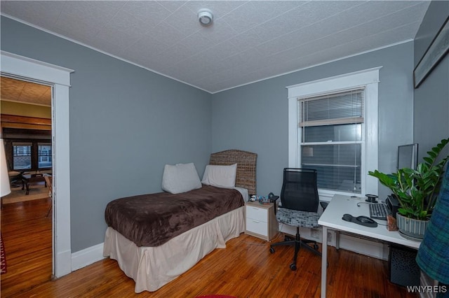 bedroom featuring baseboards and wood finished floors