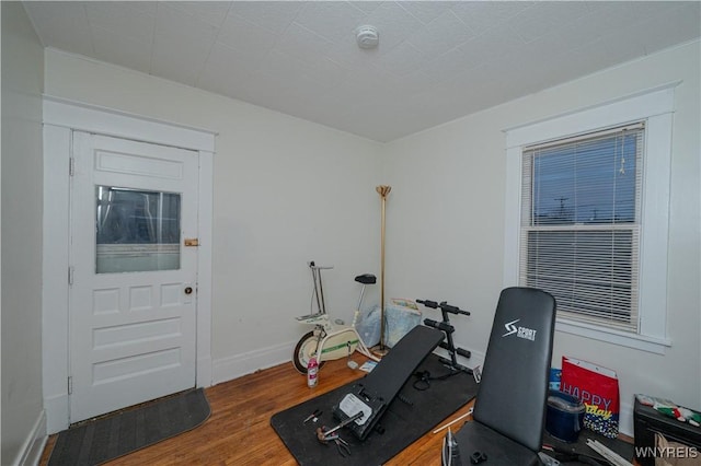 exercise area with wood finished floors and baseboards