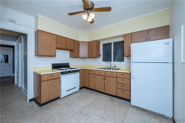 kitchen featuring light countertops, white appliances, backsplash, and a sink